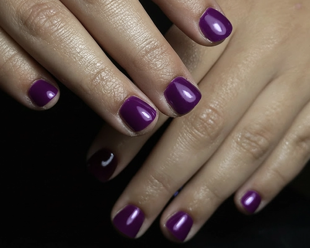 Manicura en tonos morados con tratamiento de Kapping Acrílico.