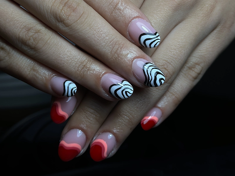 Uñas acrílicas con dibujo de ondas en blanco y negro.
